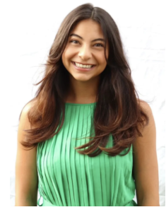 A woman in a green dress, smiling. 
